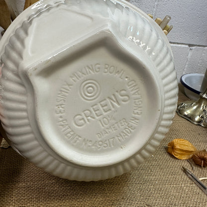 Bottom of a vintage Green's ceramic mixing bowl with embossed text on a textured burlap surface